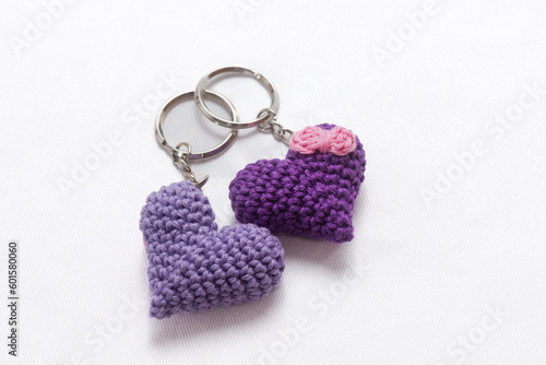 A pair of crocheted purple heart-shaped keyrings on a white background