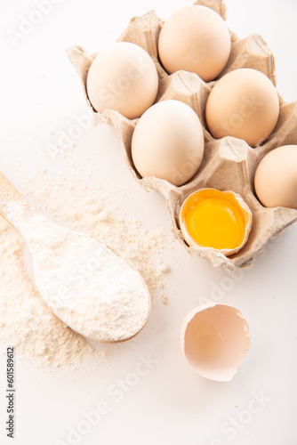 fresh chicken eggs with flour on a white background. cooking