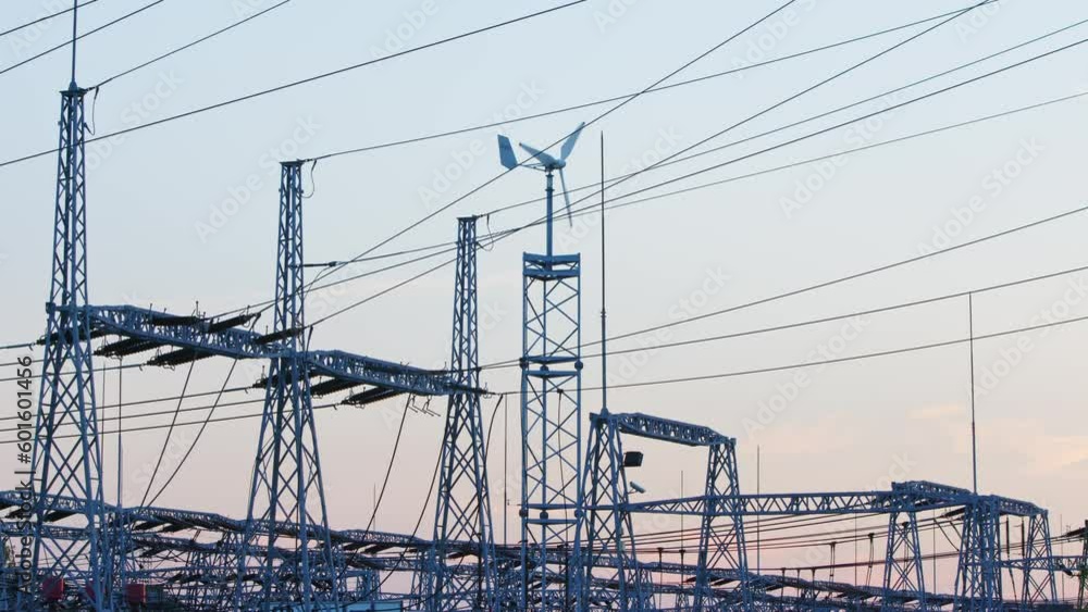 Many power lines with spinning turbine in the background, electricity towers Many power lines with spinning turbine in the background, electricity towers