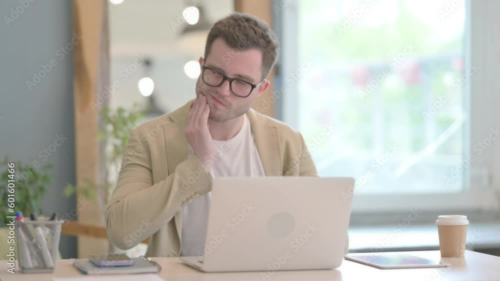Young Businessman having Toothache while Working on Laptop, infection Young Businessman having Toothache while Working on Laptop, infection