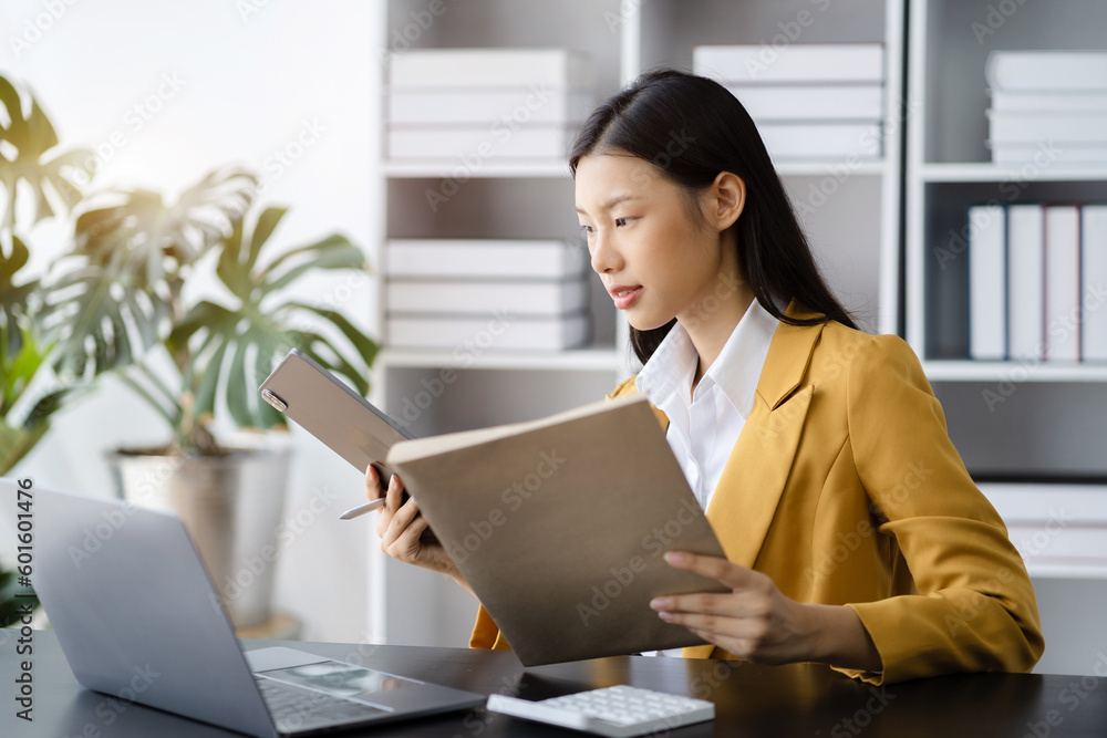 business documents on office desk with laptop and graph business diagram and Woman working at office. business documents on office desk with laptop and graph business diagram and Woman working at office.
