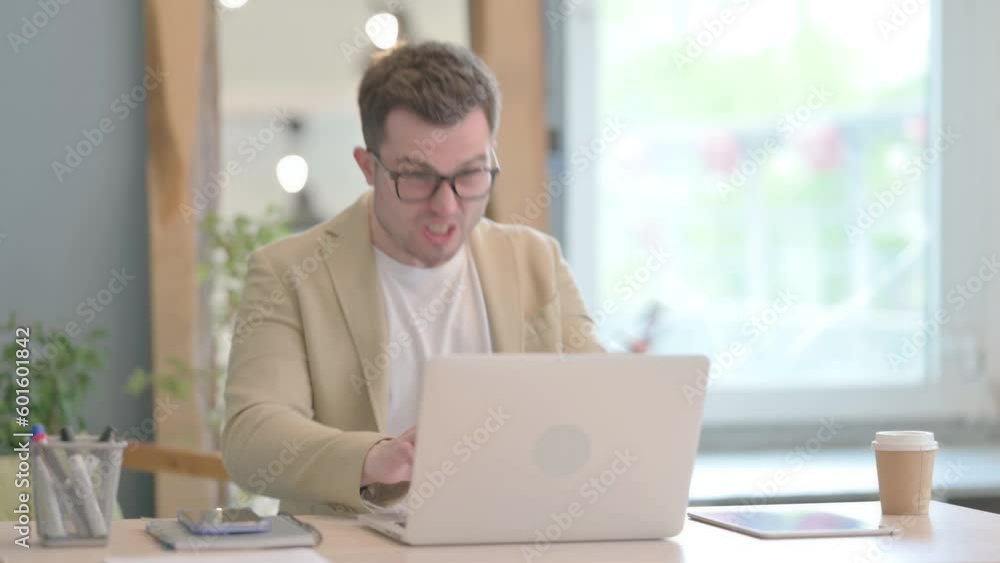 Young Businessman Shocked by Loss on Laptop Young Businessman Shocked by Loss on Laptop