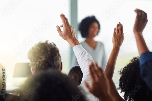 Back, business people and hands raised for questions at conference, seminar or meeting. Group, audience and hand up for question, asking or answer, crowd vote and training at workshop presentation. photo