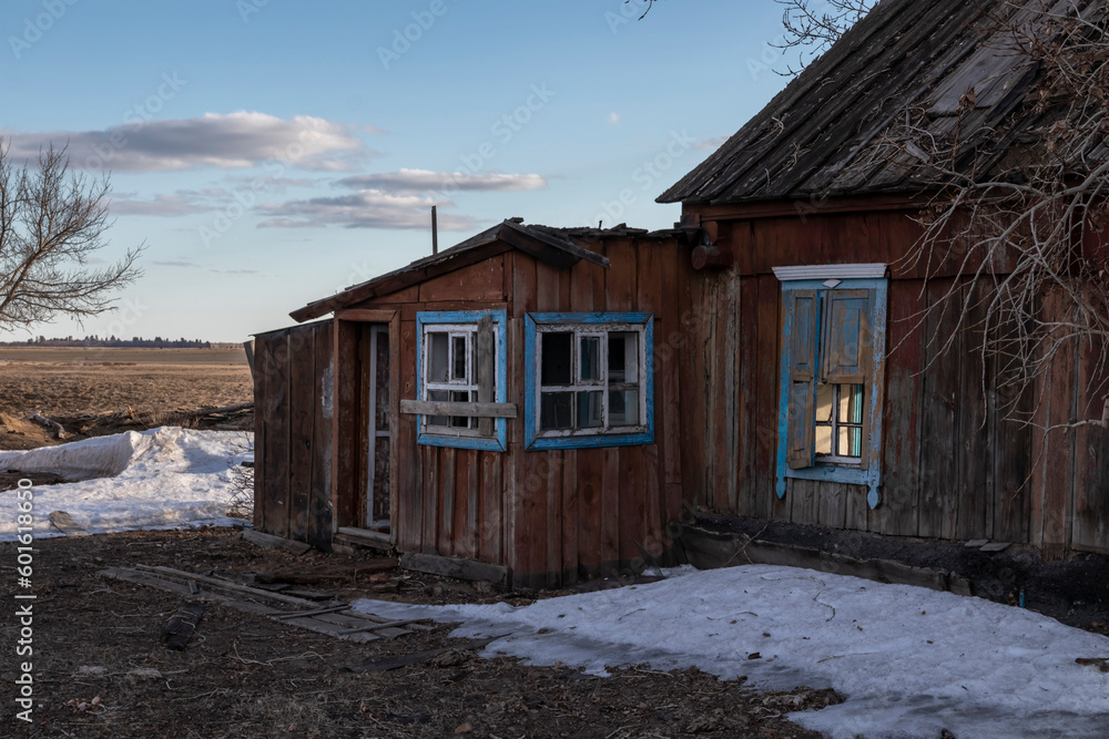abandoned house with trees and snow in the field abandoned house with trees and snow in the field