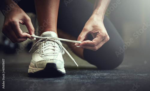 Woman tie shoe laces, hands and fitness with athlete in gym and sports with training for health. Closeup of runner sneakers, start workout in exercise studio with healthy and active female person