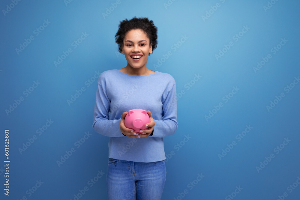 pretty young latina brunette woman keeps savings in a piggy bank pretty young latina brunette woman keeps savings in a piggy bank