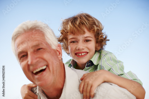 Foto Portrait, grandfather and boy with a smile, piggy back and bonding outdoor, sky and happiness