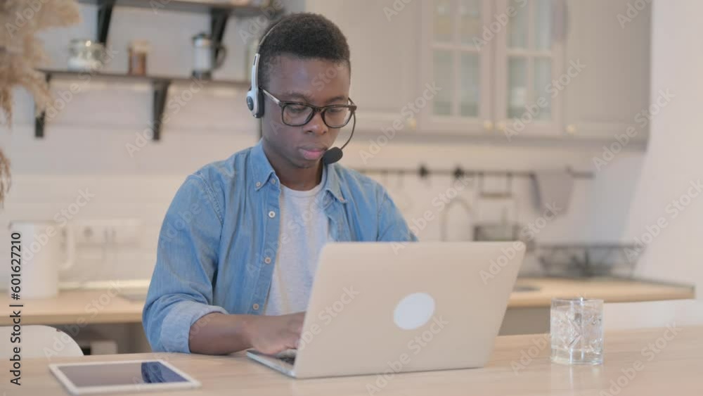 Young African Man with Headset Working on Laptop Young African Man with Headset Working on Laptop