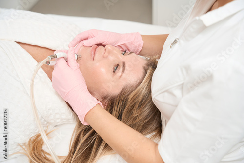 Female patient on rejuvenation procedure in aesthetic medicine clinic