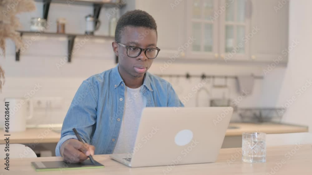 Young African Man Working on Laptop and Graphic Tablet, Designing Young African Man Working on Laptop and Graphic Tablet, Designing