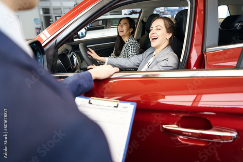 Two happy laughing women sitting in red car