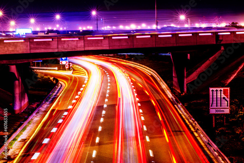 Night lights, city and highway with driving infrastructure in cape town with road travel development. Transportation, neon lighting and urban street in the evening and dark in Africa rush and blur
