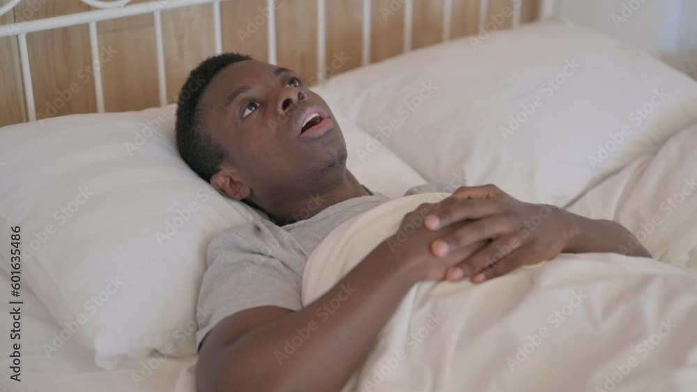 Shocked Young African Man Waking Up in Despair after Nightmare Shocked Young African Man Waking Up in Despair after Nightmare
