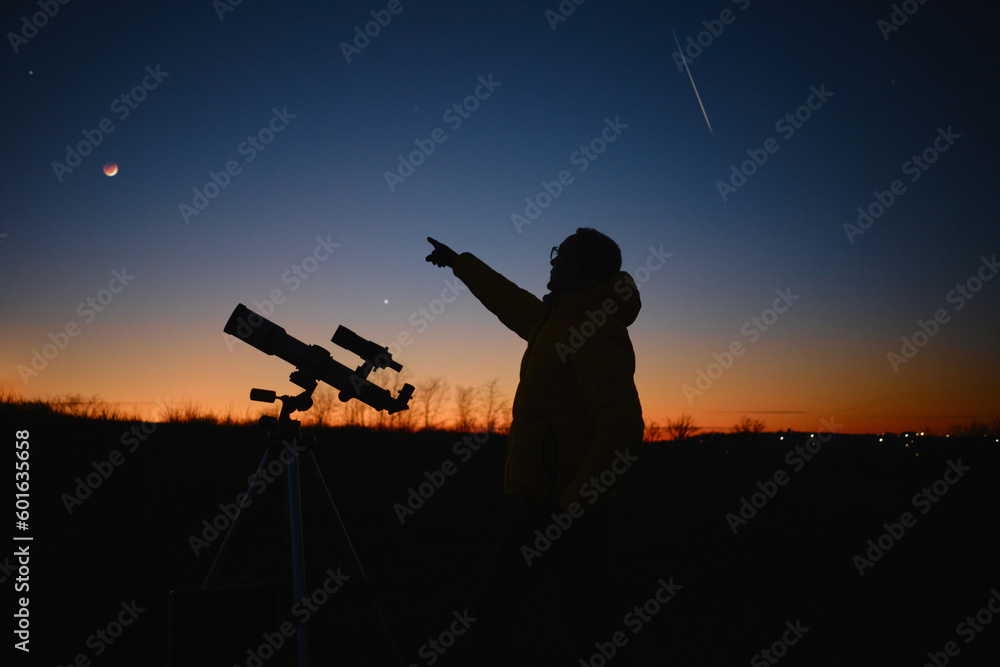 Astronomer looking at the starry skies, planets, meteor shower and lunar eclipse with a telescope. Astronomer looking at the starry skies, planets, meteor shower and lunar eclipse with a telescope.