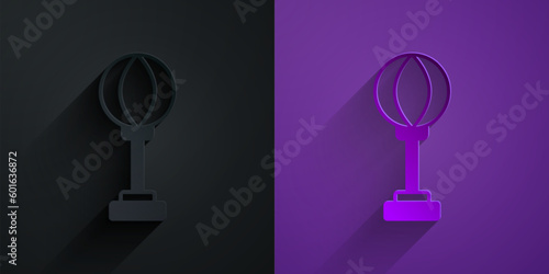 Paper cut Punching bag icon isolated on black on purple background. Paper art style. Vector