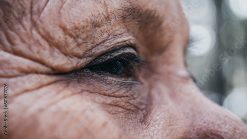 Photo of an old female's eye that looks like fills with hope but still hopeless and tired at the same time. Look at the future, and remind the past.