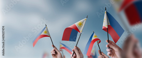 A group of people holding small flags of the Philippines in their hands
