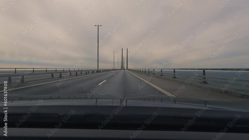 Driving on the Oresund bridge crossing the border between Denmark and Sweden. Highway on a large suspension bridge. Driving on the Oresund bridge crossing the border between Denmark and Sweden. Highway on a large suspension bridge.