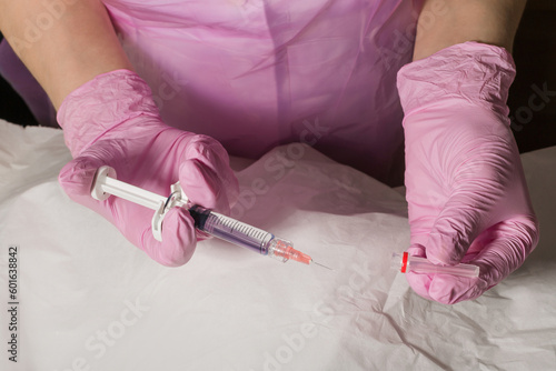 Preparations for injection techniques. Doctor cosmetologist holds a lip augmentation drug in his hands before the procedure in the clinic of aesthetic medicine photo