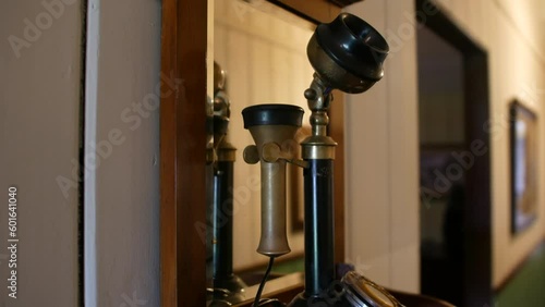 A vintage rotary telehone and mouth piece on a shelf in front of a mirror. photo