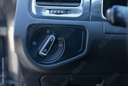 Close up of light control in car. Headlight switch, fog lights, automatic control of switching on and off the car light. Circular lights control black switch.