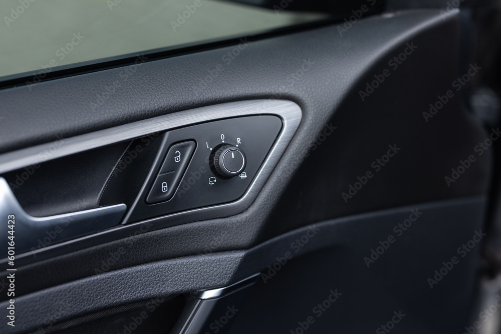 Window control buttons in modern luxury sport car. Car leather interior details of door handle with windows controls and adjustments. Car window controls. Door handle with power window control