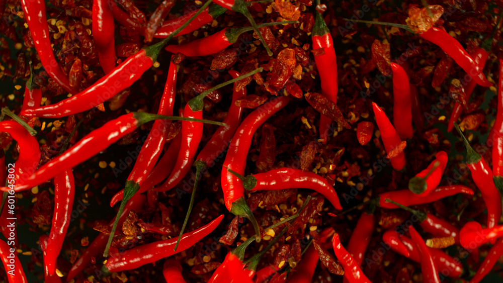 Fototapeta premium Chilli peppers flying up in the air. Freeze motion. Isolated on black background.