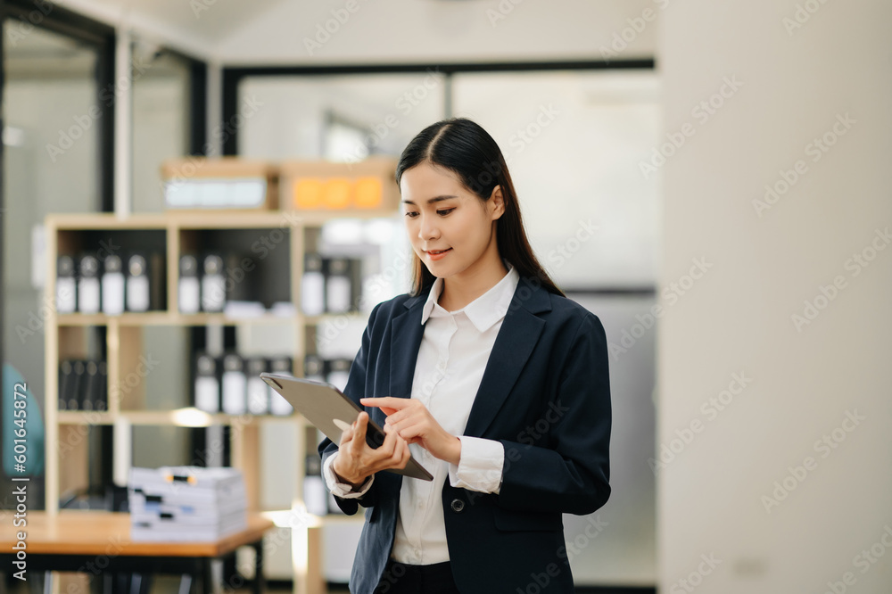 Obraz premium Confident business expert attractive smiling young woman holding digital tablet on desk in office..