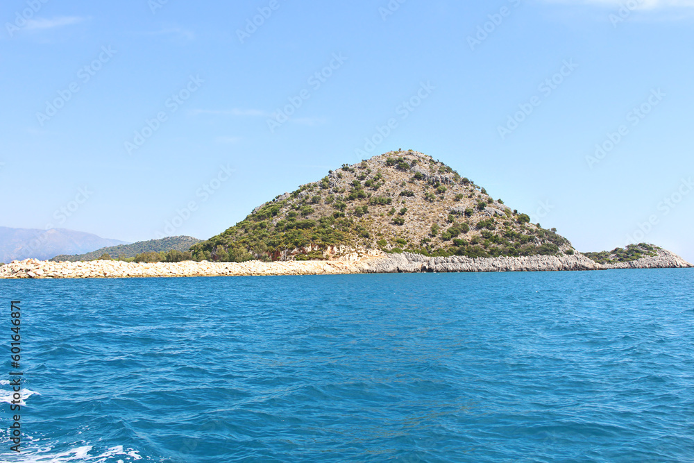 Panoramic view of hillside mountain with trees, stone breakwater. View from the sea. Landscape, Turkey
