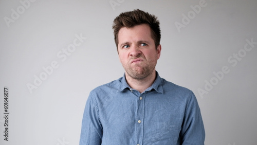 European young man is hesitating and unwilling to make decisions. He is upset about having to do unpleasant work.