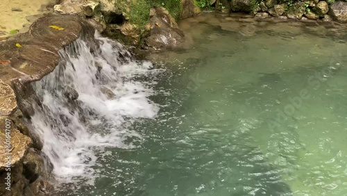 Beautiful waterfall with clear water is name Ekowisata Sungai Mudal in Kulon Progo, Yogyakarta, Indonesia. Waterfall with many beautiful plants and mosses. Concept for forest day, earth day. photo