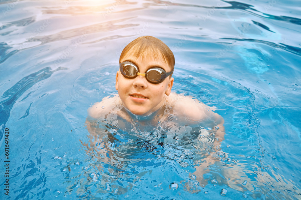 Smiling boy portrait in swimming, Child swim in the pool, sunbathes, swimming in hot summer day. Relax, Travel, Holidays, Freedom concept.
