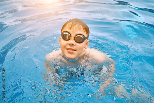 Smiling boy portrait in swimming, Child swim in the pool, sunbathes, swimming in hot summer day. Relax, Travel, Holidays, Freedom concept. 