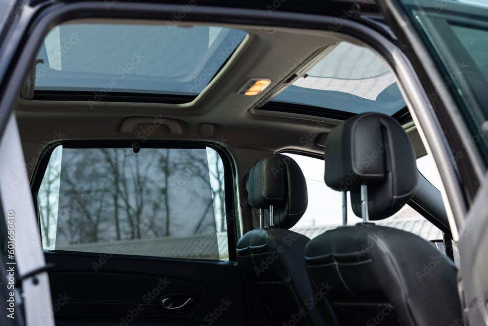 Hatch in car roof. Panoramic glass sun roof in the car. Clean glass and view from inside to the sky. Double sunroof hatch with tinted glass. Automotive sunroof closeup. High quality photo.
