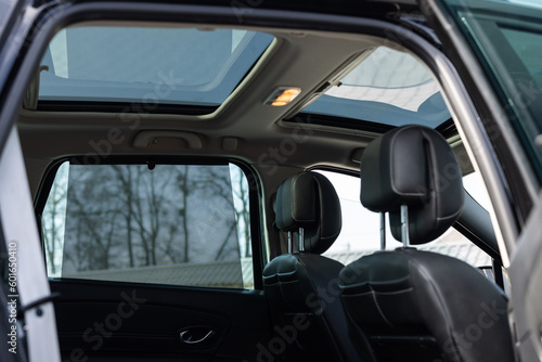 Hatch in car roof. Panoramic glass sun roof in the car. Clean glass and view from inside to the sky. Double sunroof hatch with tinted glass. Automotive sunroof closeup. High quality photo.