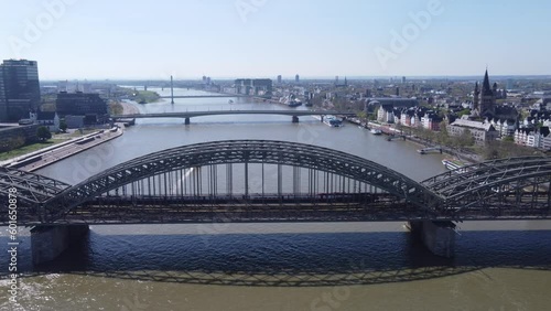 Aerial view, Train moving on Triple Arch Steel 4 Track Railway Bridge Hohenzollern.
Cityscape of Cologne Riverside, modern glass buildings, City Hall and Classic style Houses in Background. photo