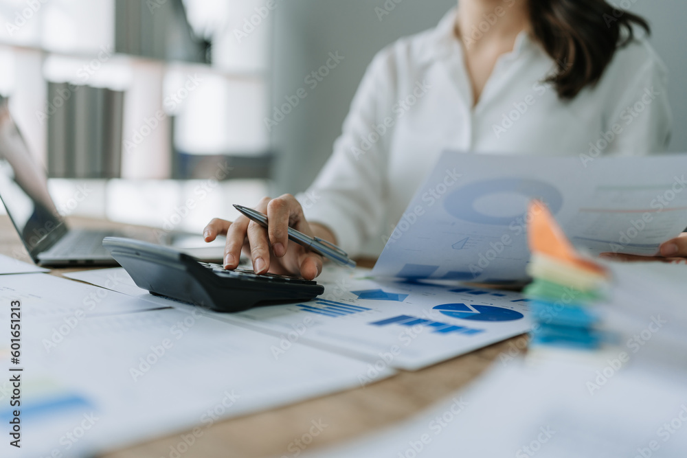 Fototapeta premium Young asian female work with financial papers at home count on calculator before paying taxes receipts online, planning budget glad to find chance for economy saving money, audit concepts.