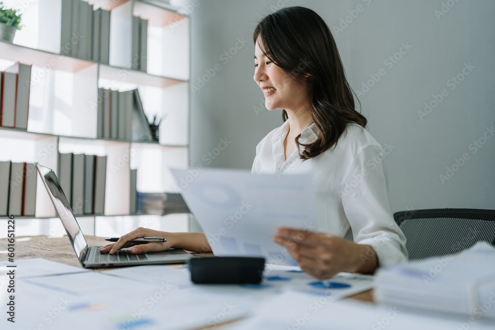 Young asian female work with financial papers at home count on calculator before paying taxes receipts online, planning budget glad to find chance for economy saving money, audit concepts Young asian female work with financial papers at home count on calculator before paying taxes receipts online, planning budget glad to find chance for economy saving money, audit concepts