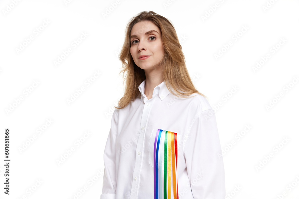Portrait of young smiling woman wearing white shirt with rainbow line symbolizing lgbt tolerance. Model posing on white background. Concept of lgbt community, support, love, human rights, pride month Portrait of young smiling woman wearing white shirt with rainbow line symbolizing lgbt tolerance. Model posing on white background. Concept of lgbt community, support, love, human rights, pride month