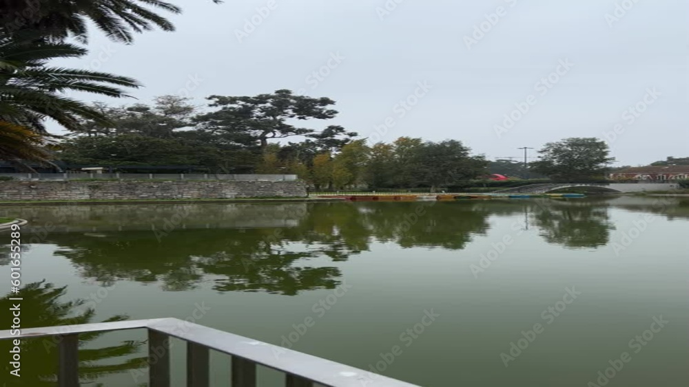 Panoramic view of lake in park in Lisbon on cloudy winter day. Vertical video