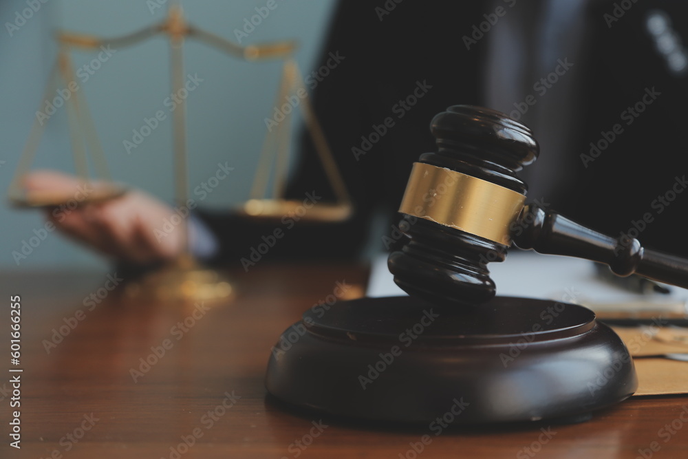 Business and lawyers discussing contract papers with brass scale on desk in office. Law, legal services, advice, justice and law concept picture with film grain effect Business and lawyers discussing contract papers with brass scale on desk in office. Law, legal services, advice, justice and law concept picture with film grain effect