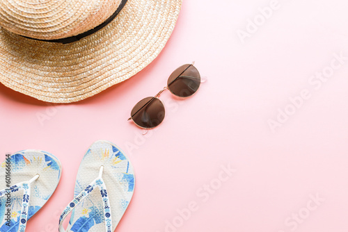 Flat lay summer on a pink background. Summer accessories. Hat, slippers, glasses