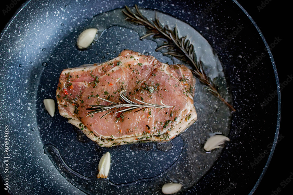 Chef cooking juicy beef meat on frying pan with rosemary and garlic, uses kitchen utensils. Process of roasted steak cooking. Chef cooking juicy beef meat on frying pan with rosemary and garlic, uses kitchen utensils. Process of roasted steak cooking.