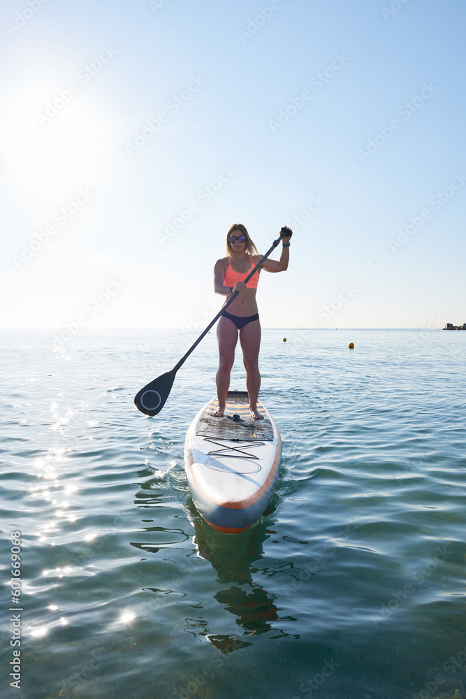 Obraz premium Female surfer on SUP board