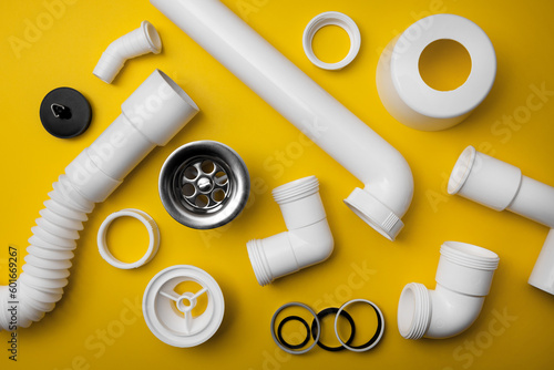 Foto plumbing pvc plastic drain parts on yellow background. top view