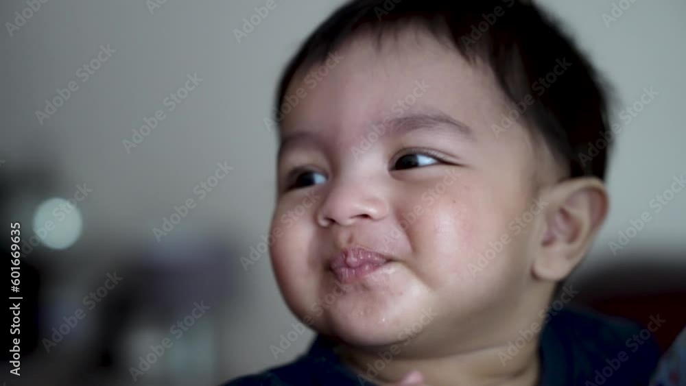 8 Month Old Baby Boy Cheekily Smiling Whilst Eating A Snack. Slow Motion 8 Month Old Baby Boy Cheekily Smiling Whilst Eating A Snack. Slow Motion