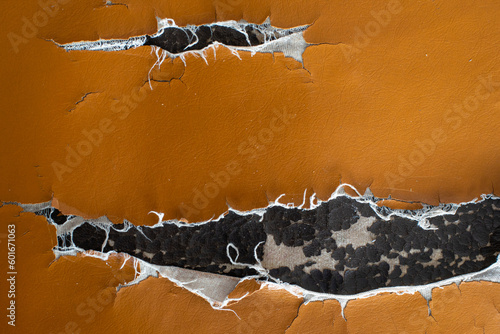 Tear damaged old synthetic leather brown sofa. Old cracked damaged leather on sofa synthetic leather upholstery.