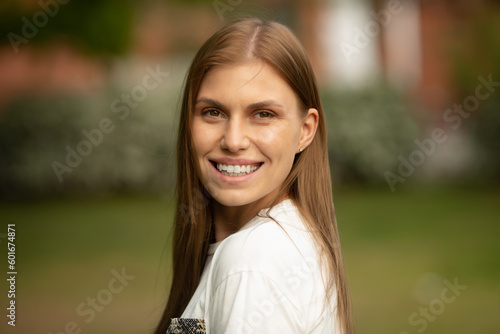 Outdoors portrait of beautiful young girl laughing. Happy woman with long hair excited with toothy smile.