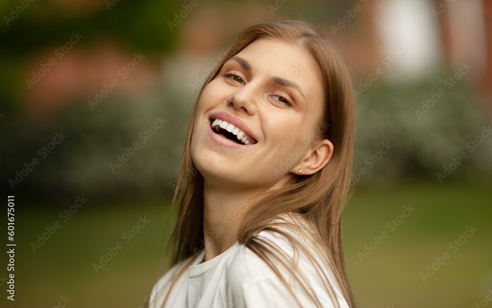 Outdoors portrait of beautiful young girl laughing. Happy woman with long hair excited with toothy smile. Outdoors portrait of beautiful young girl laughing. Happy woman with long hair excited with toothy smile.