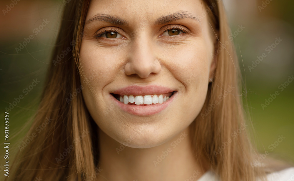 Fototapeta premium Outdoors portrait of beautiful young girl laughing. Happy woman with long hair excited with toothy smile.